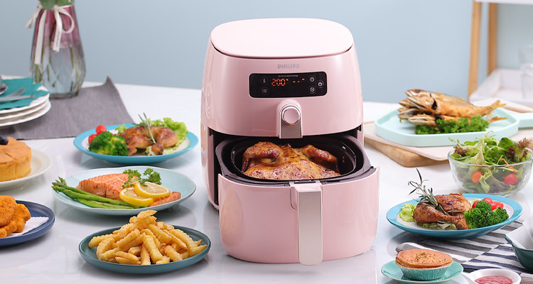 Mood shot of the Philips Premium Digital Airfryer with a variety of dishes 