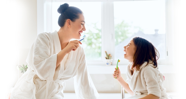 Mother and daughter brushing their teeth together with GLISTER oral care 3 