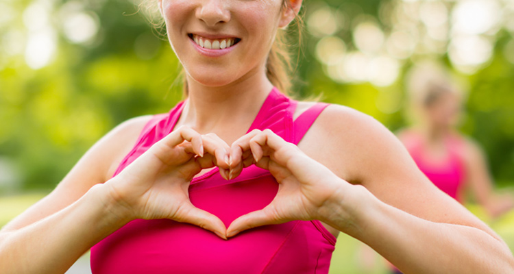 image of woman posing with hands in a heart shape over her chest