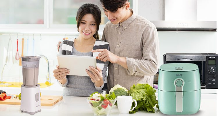 Image of a couple in a kitchen with a mini blender, airfryer and breadmaker oven toaster 